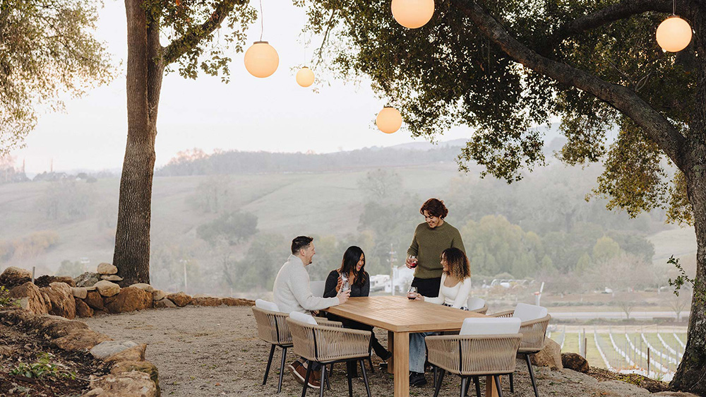 Group enjoying wine at outdoor tasting in the Grove at Jada Vineyard